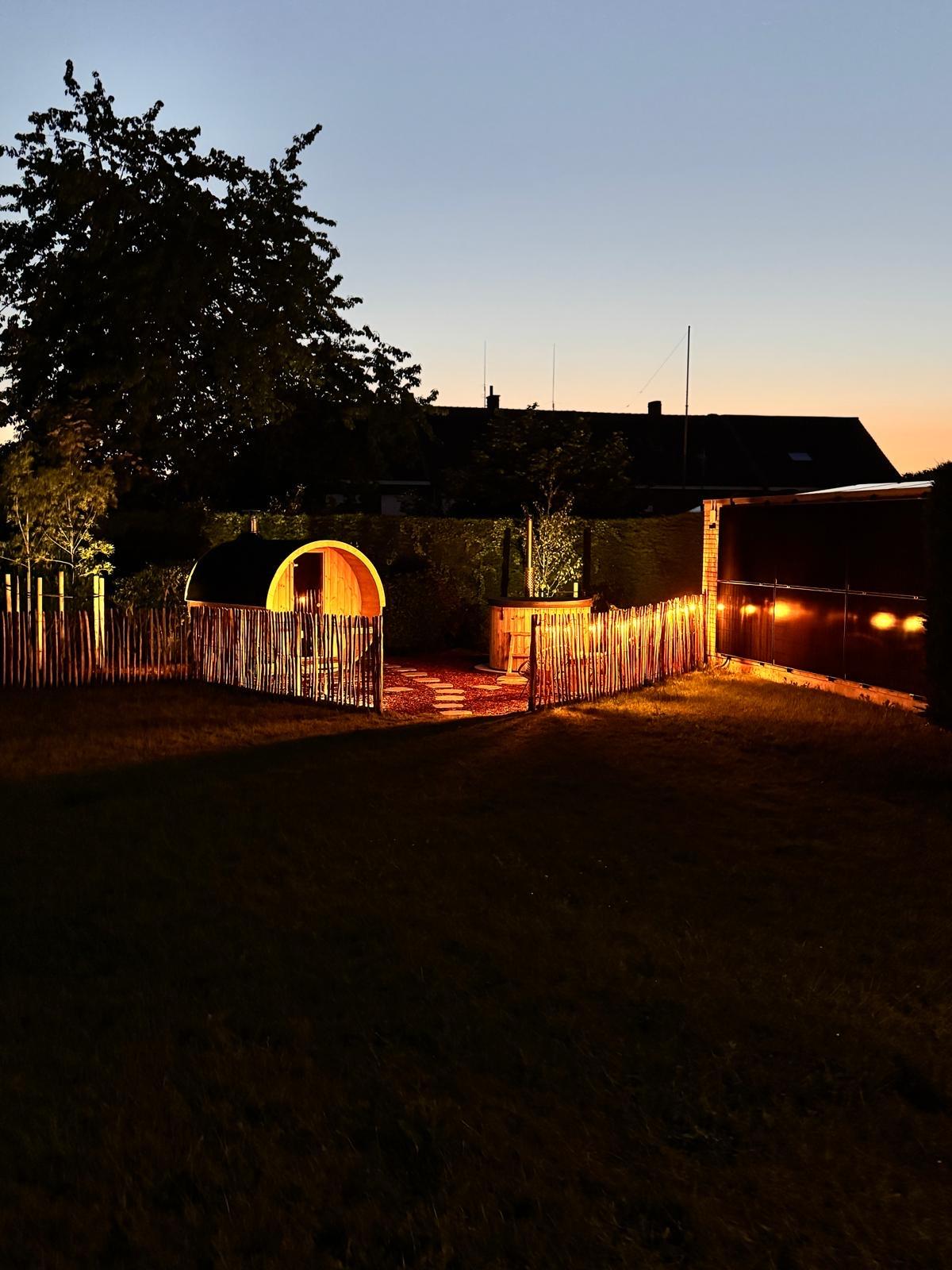 Sauna en hot tub met sfeerverlichting bij zonsondergang