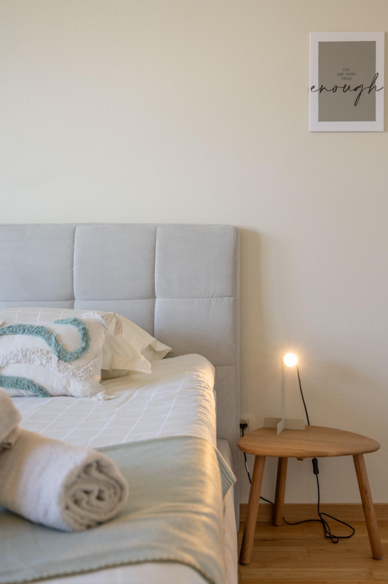 Detail van bed met nachtkastje en lamp