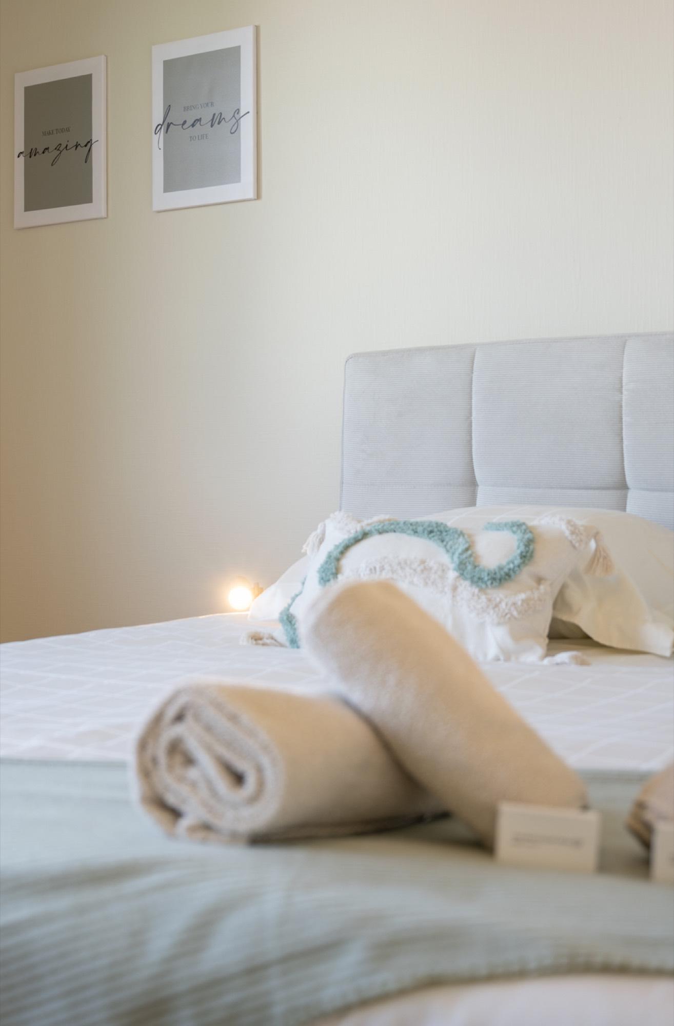 Opgemaakt bed met handdoeken en kunst