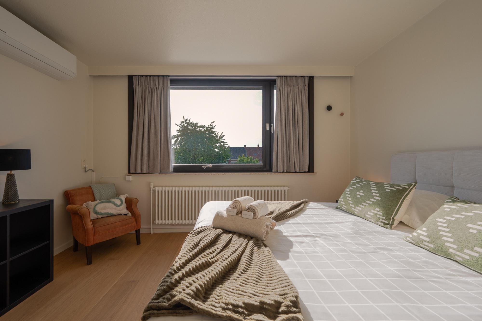 Slaapkamer met fauteuil en raam