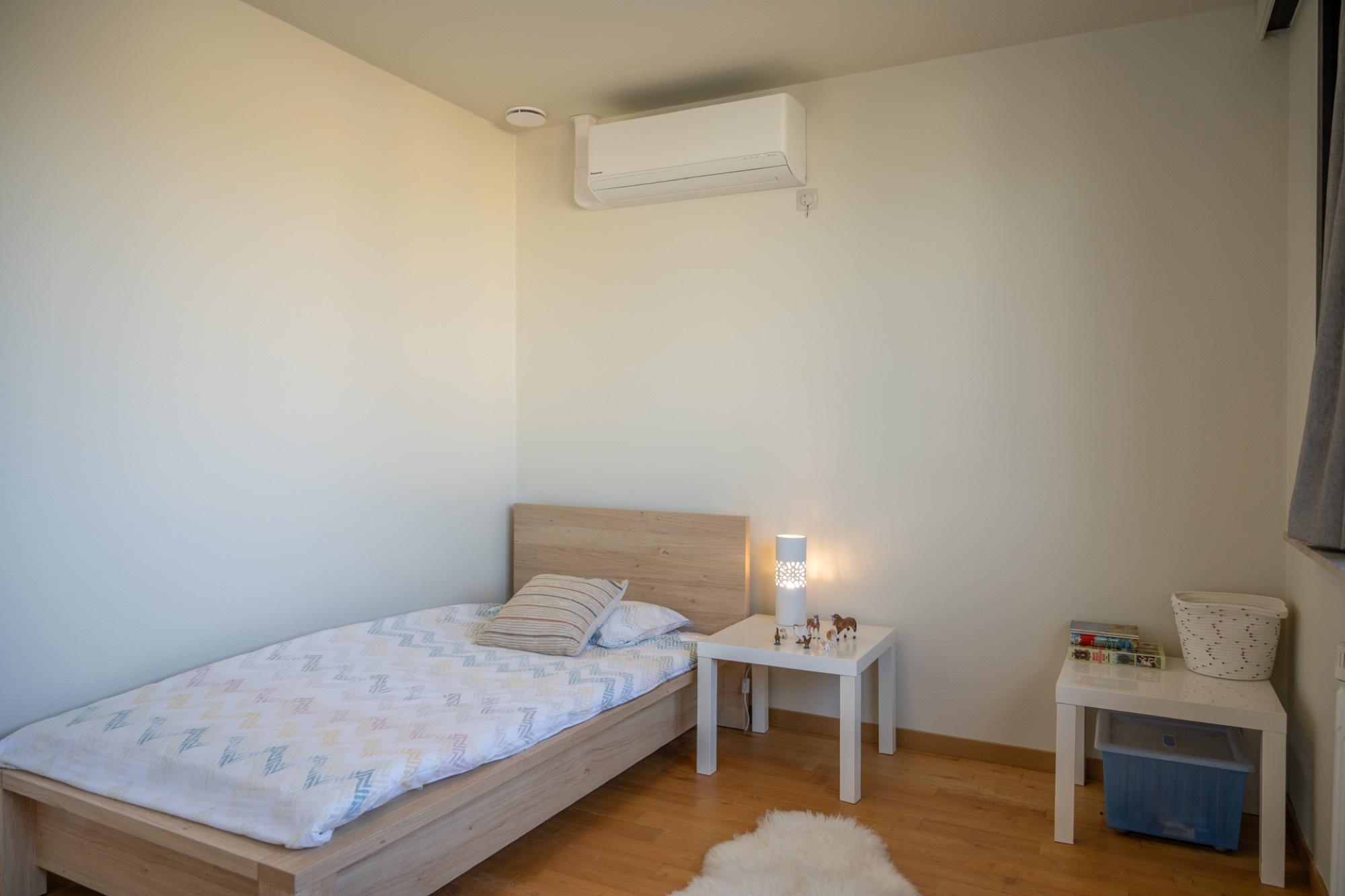 Eenpersoonsslaapkamer met houten bed en lamp