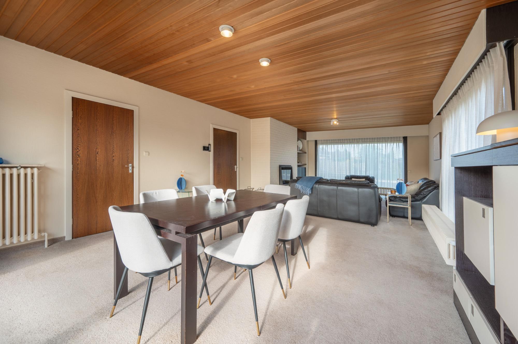 Woonkamer met houten plafond en eettafel