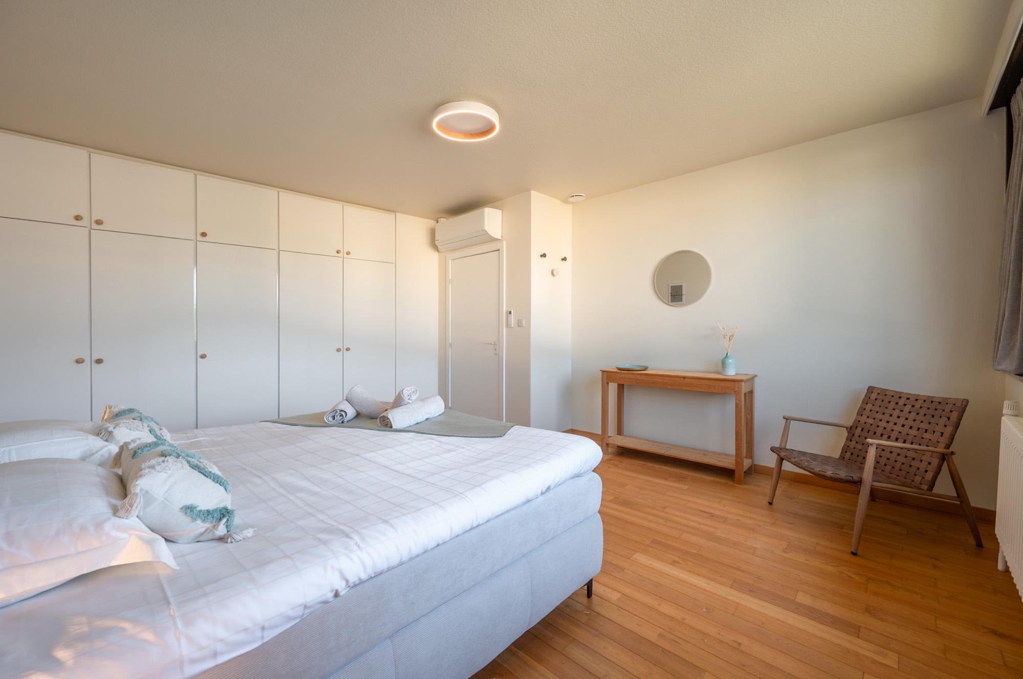Slaapkamer met kastenwand en zithoek