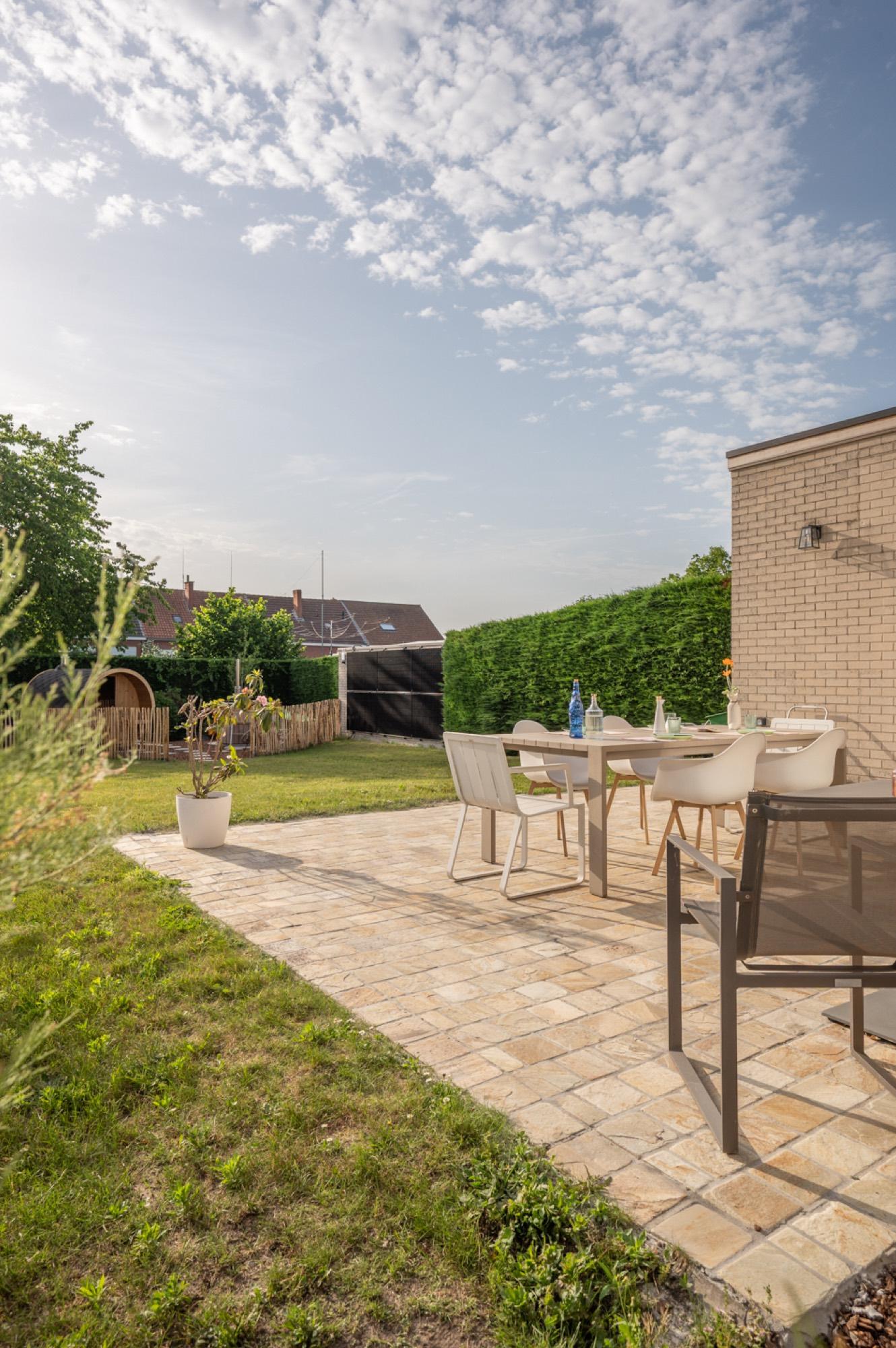 Zonnige tuin met terras en eethoek