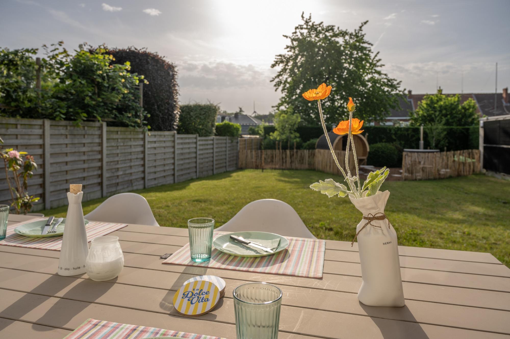 Buitentafel met bloemen en zonnige tuin