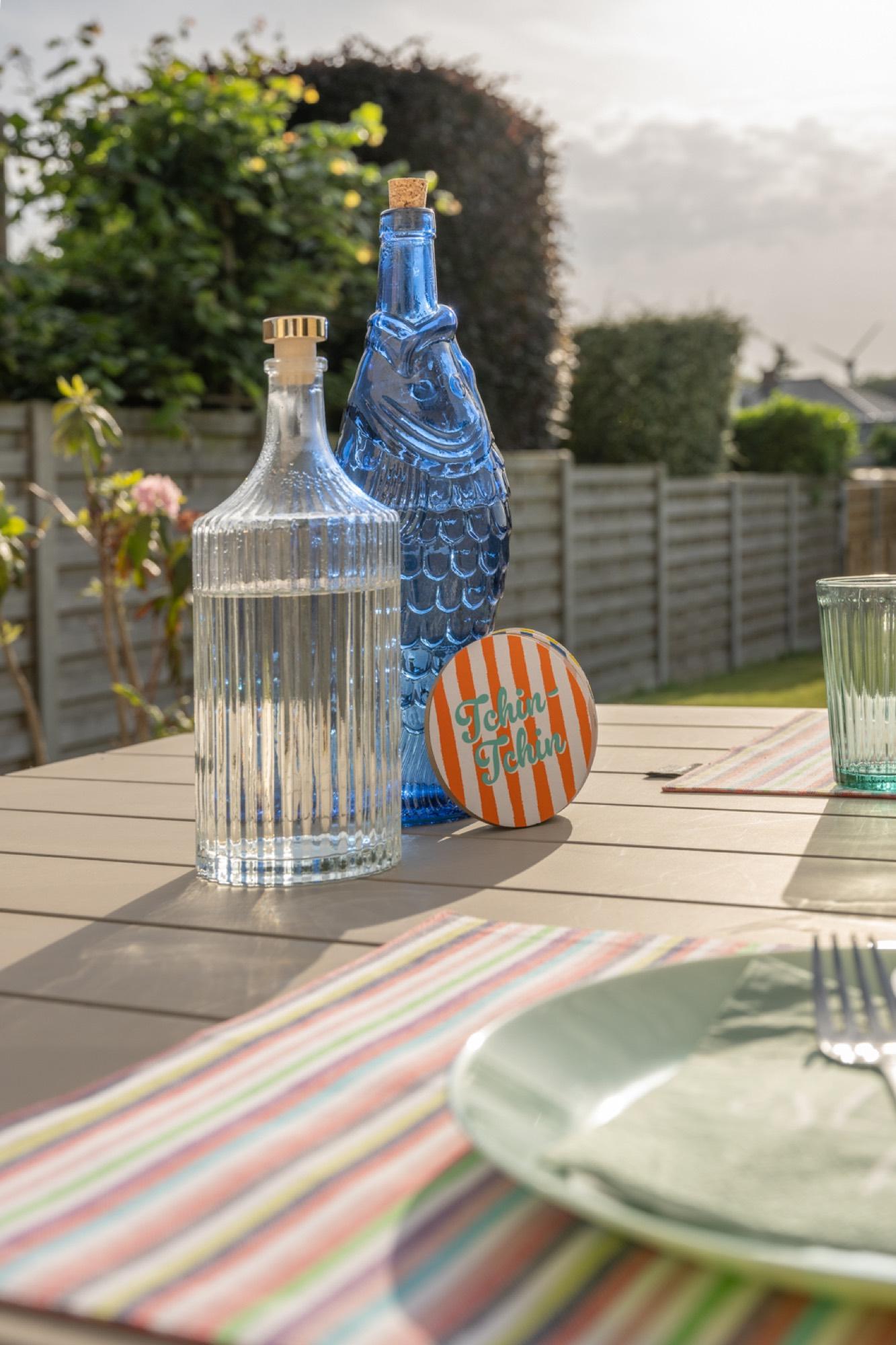 Gedekte tuintafel met karaffen en tuin