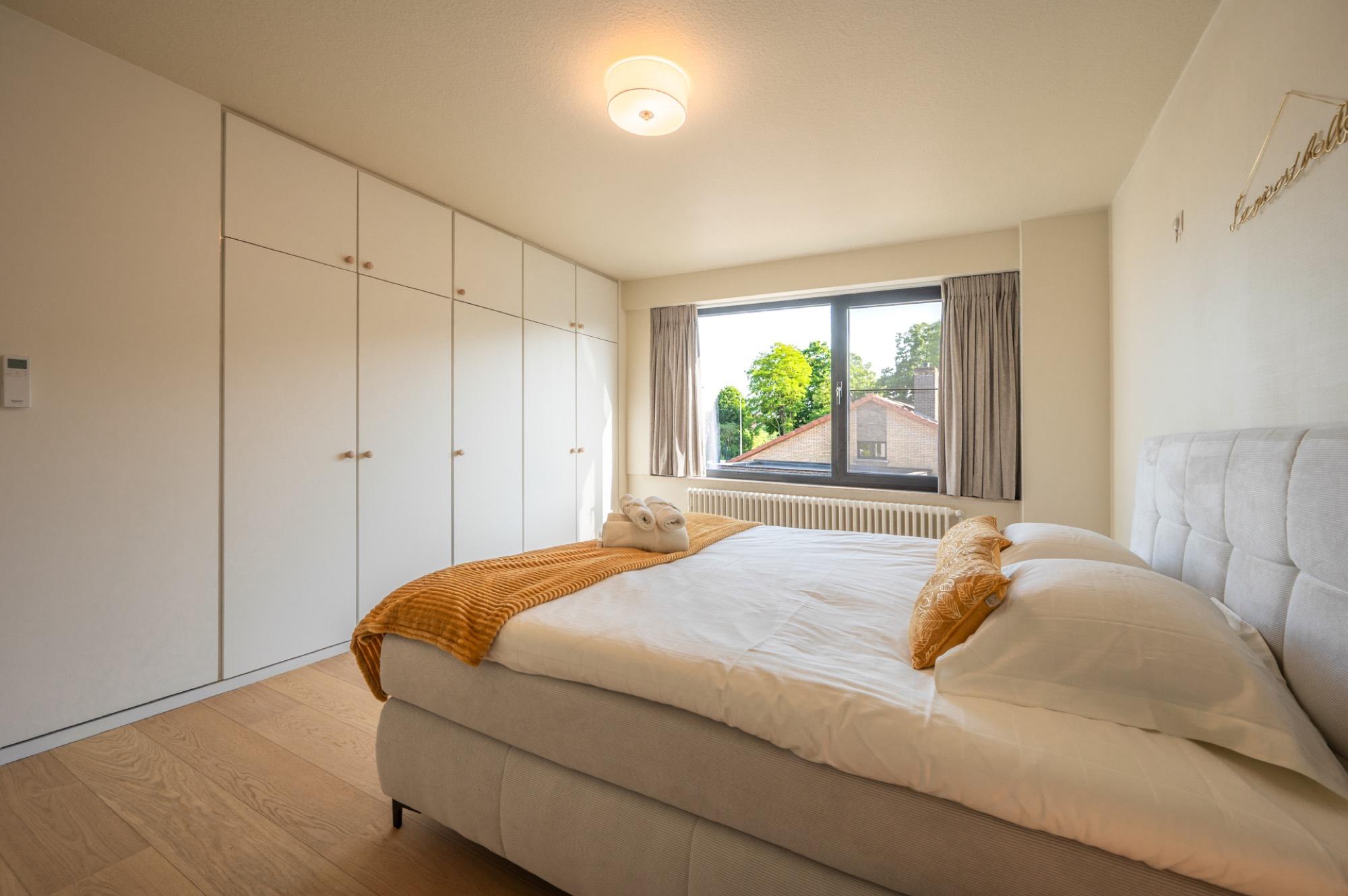 Slaapkamer met kastenwand en okergele accenten